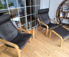 Ikea Poang brown leather chairs and matching footstool with occasional table