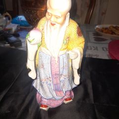 Beautiful Large Chinese Shou Xing porcelain figurine depicting the God of Longevity. It features an elderly man with a prominent bald head, holding a peach, which symbolizes long life, Postage Available, no chips or cracks