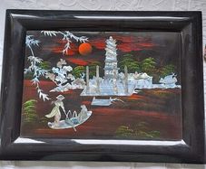 Vintage Vietnamese black lacquer wall plaque featuring intricate mother-of-pearl inlay.