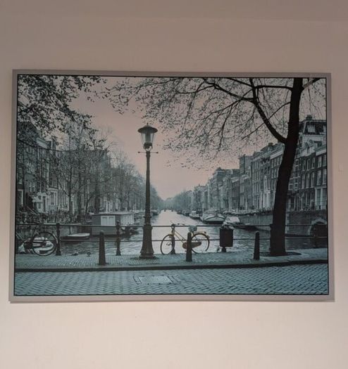 Two framed city pictures of Paris and Amsterdam