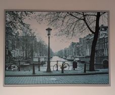 Two framed city pictures of Paris and Amsterdam