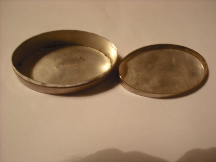 a antique pill box with golfer on it