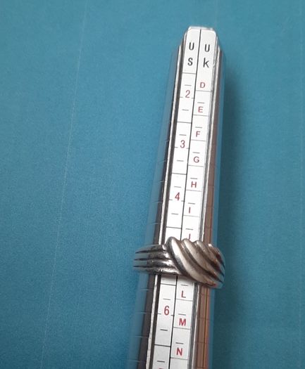 Silver ring clasping hands