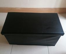 Black faux-leather folding storage ottoman
