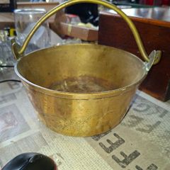 Antique Brass Cauldron Jam Pan features a Polished Brass finish with a Swing Handle secured by riveted joints, Historically used as a "jam pan" for making preserves over an open fire or stove-top. Material: Constructed from solid brass