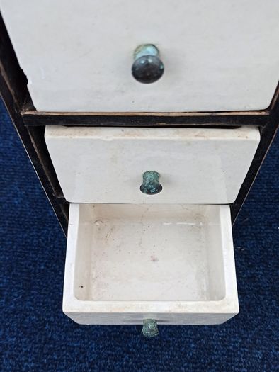 Small vintage wooden storage unit with heavy ceramic drawers with brass knobs