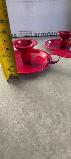Set of 2  Red enamel candlestick holder and drip tray featuring a Considered by Helen James 12.00 euro each.