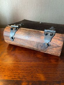 antique A wooden box in the form of a book, having brass escutcheon and black metal hinges. 18 x 15cm.