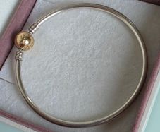 Pandora Moments two-tone bangle ir sterling silver with a 14k yellow gold ball clasp. (Size approx 19cm) for the right size please check all the photos (the bracelet is in very good condition)
