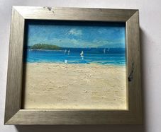 original impasto oil painting on canvas depicts a sunny coastal beach scene with sailboats on the water and a headland in the background