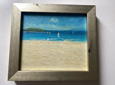 original impasto oil painting on canvas depicts a sunny coastal beach scene with sailboats on the water and a headland in the background