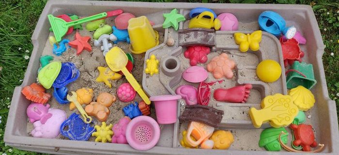 Sandbox with lid and bunch of sand toys.