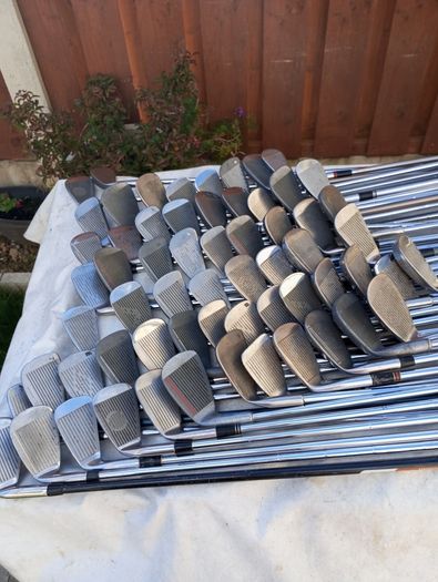A selection of golf clubs and bags. All right handed clubs.