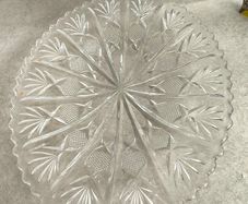 Clear cut-glass or crystal flat cake plate or serving platter featuring a radial starburst and fan-cut pattern