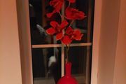 Pretty red vase with single artificial flower stem