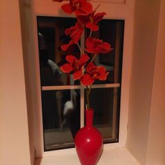 Pretty red vase with single artificial flower stem