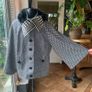 black and white short jacket with detachable faux fur scarf detail and cape sleeves. Image 2