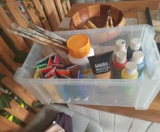 box of acrylic paints and brushes