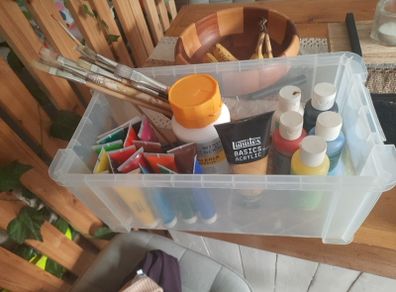 box of acrylic paints and brushes