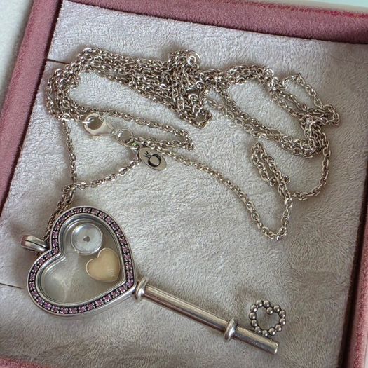 Pandora sterling silver key necklace with a heart,shaped floating locket and pink sparkling stones. Includes the two petite charms
