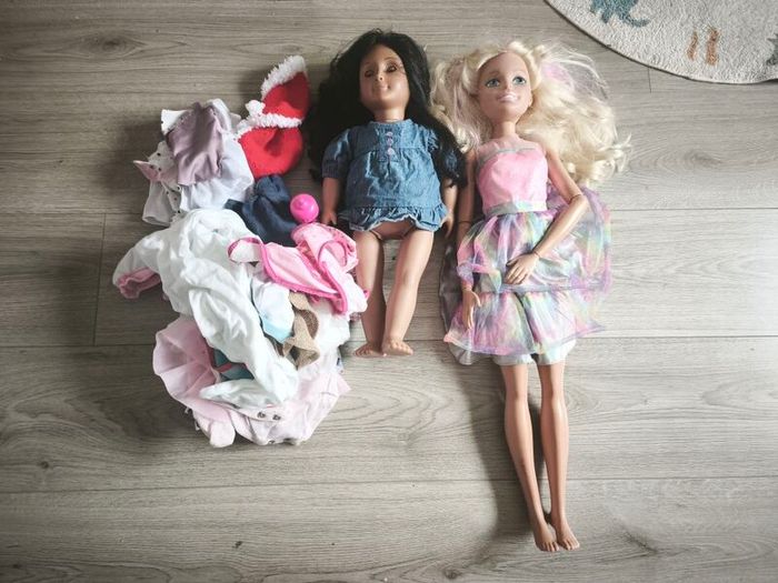 2 dolls with some baby doll clothes