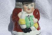 An antique TOBY JUG (Staffordshire potteries) - a seated toby holding his ale jug and cup (late 19th century). Excellent condition. About 14cm height.