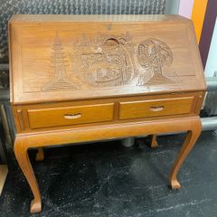 This is a vintage mid-20th-century Asian carved wood writing bureau featuring an intricate hand-carved traditional landscape on the drop-front lid.