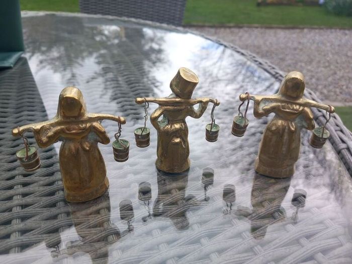 3 brass figures with water buckets, D18 post 7e