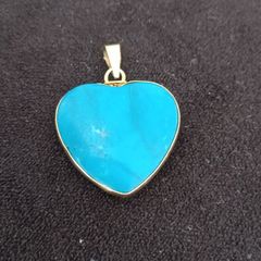 The heart shaped turquoise pendant has an 18ct gold