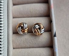 Beautiful silver and rose gold-tone knot stud earrings.