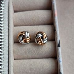 Beautiful silver and rose gold-tone knot stud earrings.