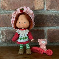 Vintage Strawberry Shortcake doll with her hat, comb and pet.