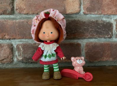 Vintage Strawberry Shortcake doll with her hat, comb and pet.