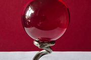 Red crystal/glass ball and metal serpent stand.