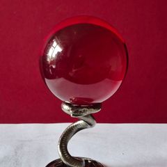 Red crystal/glass ball and metal serpent stand.