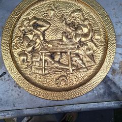 Large Brass Wall Charger Old World Pub Scene, Embossed Tavern scene of 17th-century Pubs. This is a striking brass wall hanging, with an Old World pub scene. It is pressed hammered brass. The raised relief image features a pair of men in Old World dress, 