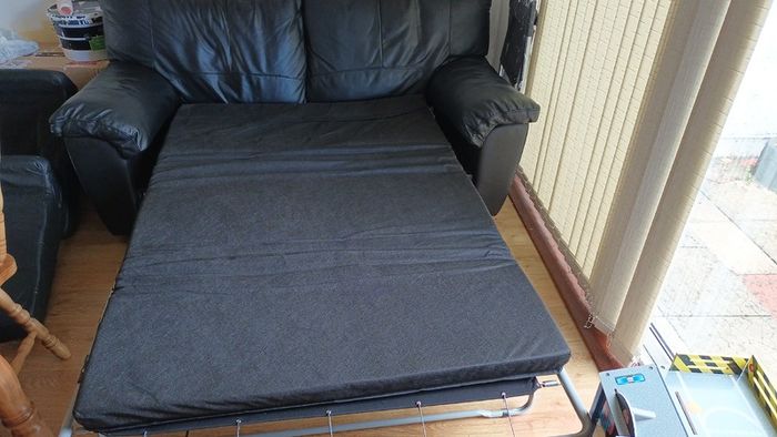 Black leather two-seater sofa-bed