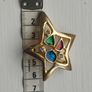 A gold star-shaped brooch. Image 8