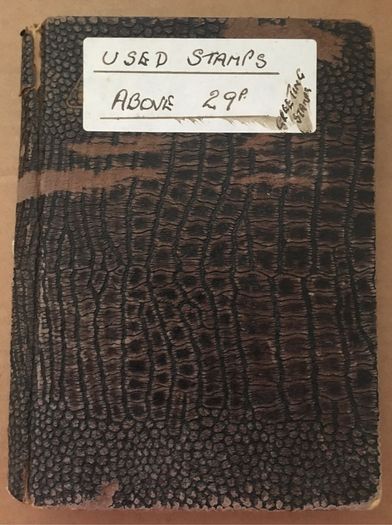 Small brown stamp stock book. 13cm x 18.5cm. 24 page / 12 leaf. Album contains used England Stamps with values over 29p
