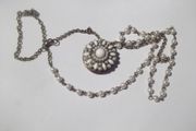 a vintage locket  penden on a long chain with pearls and white stones