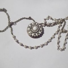 a vintage locket  penden on a long chain with pearls and white stones