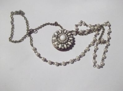 a vintage locket  penden on a long chain with pearls and white stones