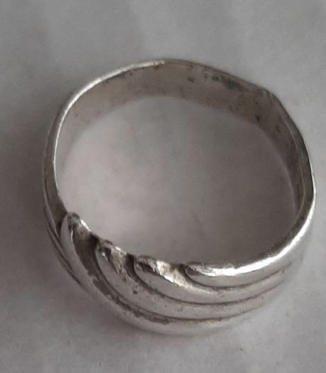 Silver ring clasping hands