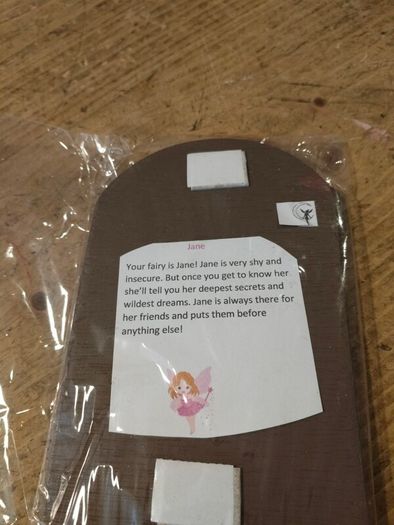 handcrafted wooden  Fairy door with red cardstock, brown flower cutouts, and decorative buttons.  various buttons acting as handles or embellishments.