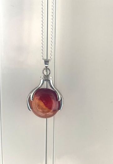 Silver tone necklace with unique hand-clasp pendant