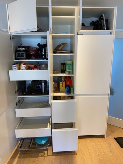 Modern white kitchen units and tall larder storage