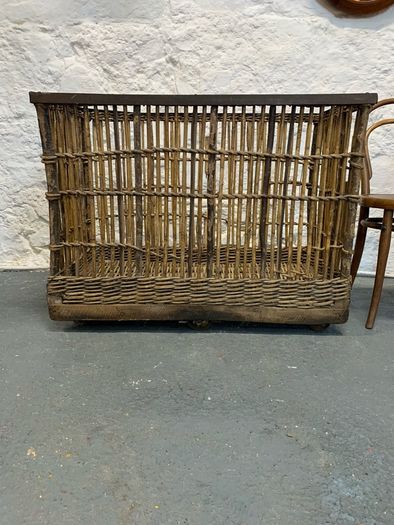 Large Victorian cane and metal laundry basket on wheels.