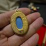 Vintage Cameo Goldtone Pendant on a Blue Background Image 5