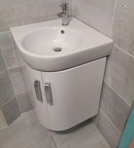 Corner wall hung vanity unit, sink and tap.