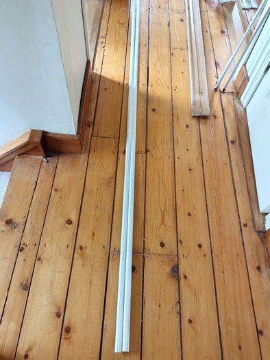 Two 2.4m lengths of white wooden moulding 10x10mm